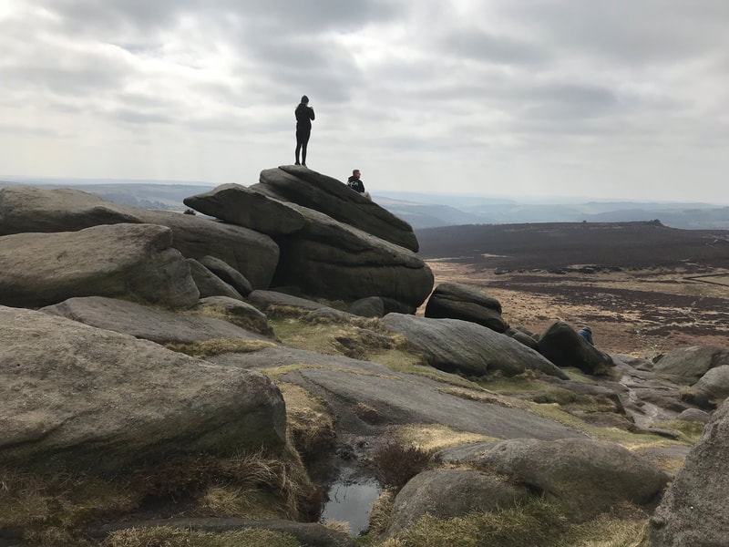 Visitors enjoying the view at Higger Tor on a Peak District scenic tour